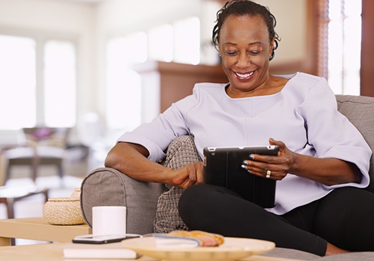A woman goes online on her tablet to research options for saving for retirement. A woman goes online to look for suitable products to help her invest for retirement.