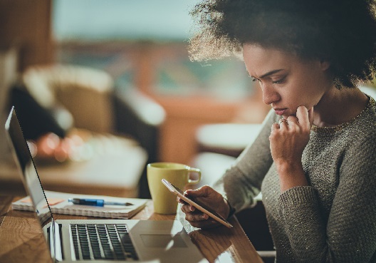 A Ghanaian woman goes online on her phone to research online safety and security.