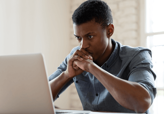 A man uses a laptop to go online and learn more about digital security and safety.
